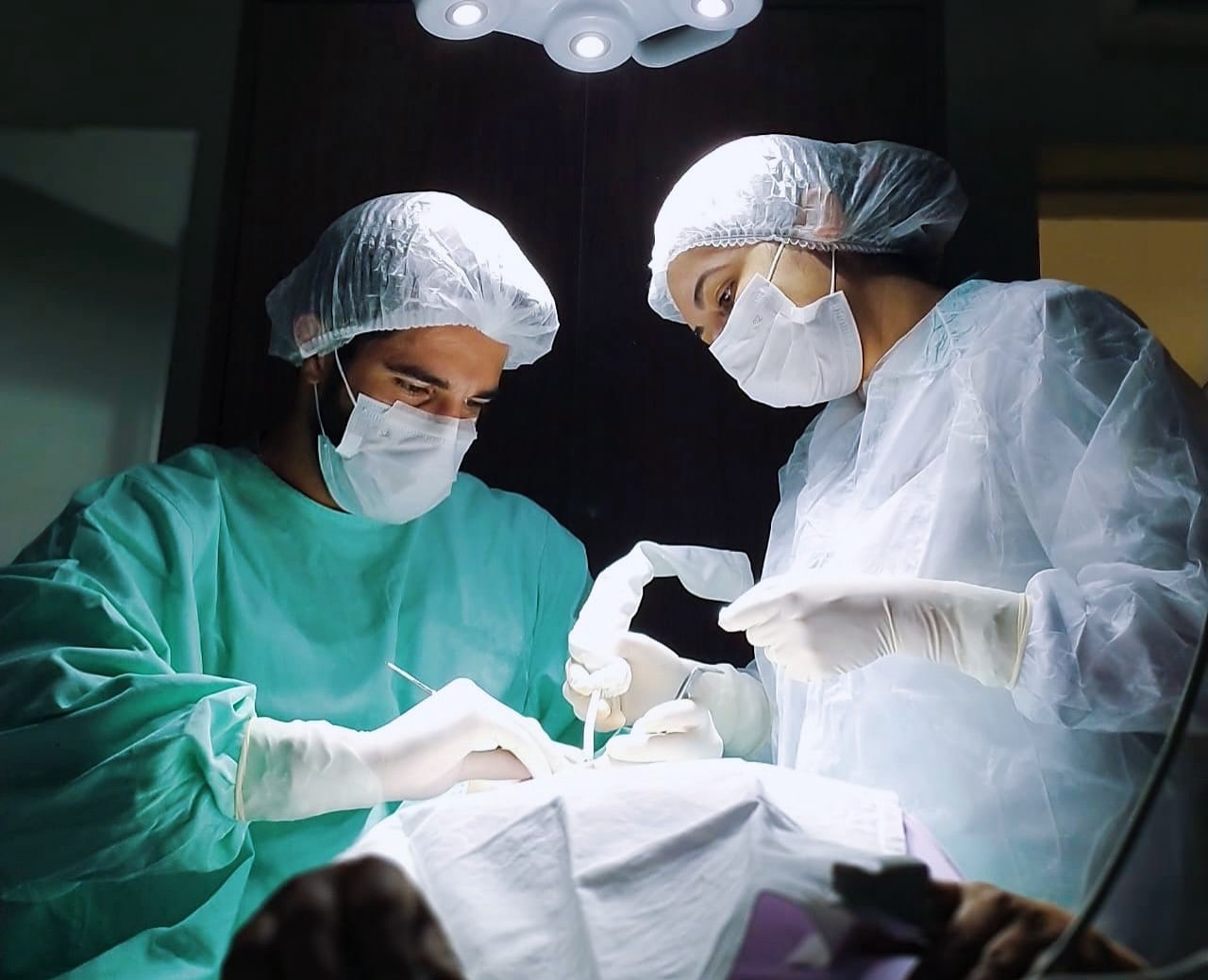 Dr. Filipe Ribeiro Cini durante um procedimento cirúrgico, com a equipe paramentada.